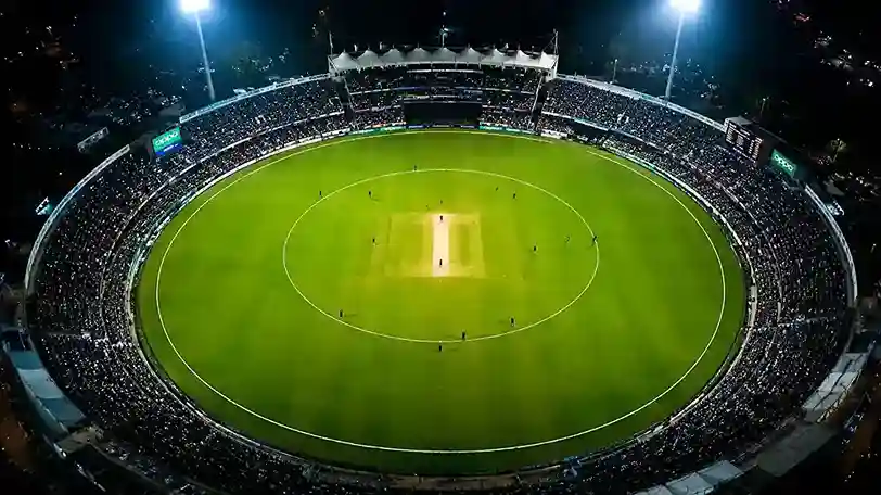 Aerial night view of a modern cricket stadium showing the official 30-yard fielding restriction circle and the outer boundary limits.