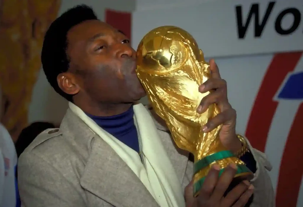 Pelé celebrating winning the 1970 World Cup with Brazil, held high by his jubilant teammates.