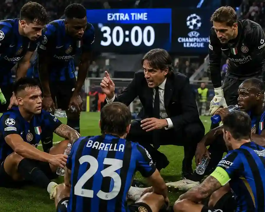 Exhausted football players sitting in a huddle listening to their manager before extra time begins.